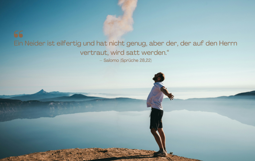Das Bild zeigt eine Person, die auf einem Berggipfel oder einer Klippe steht, mit ausgestreckten Armen und dem Blick zum Himmel gerichtet. Die Kulisse umfasst eine atemberaubende Landschaft mit einem ruhigen See, fernen Bergketten und einem klaren blauen Himmel. Die Atmosphäre vermittelt ein Gefühl von Freiheit, Zufriedenheit und innerem Frieden.

Der Bibelvers auf dem Bild stammt aus Sprüche 28,22:

"Ein Neider ist eifertig und hat nicht genug, aber der, der auf den Herrn vertraut, wird satt werden."

Dieser Spruch gehört zu den Sprüchen über Neid und hebt hervor, dass Gier und Missgunst nie zur Erfüllung führen, während Vertrauen auf Gott Zufriedenheit schenkt. Das Bild visualisiert diese Botschaft durch die offene, befreite Körperhaltung des Mannes, die ein Symbol für innere Fülle und Dankbarkeit ist – im Kontrast zur Rastlosigkeit und Unzufriedenheit, die Neid mit sich bringt.